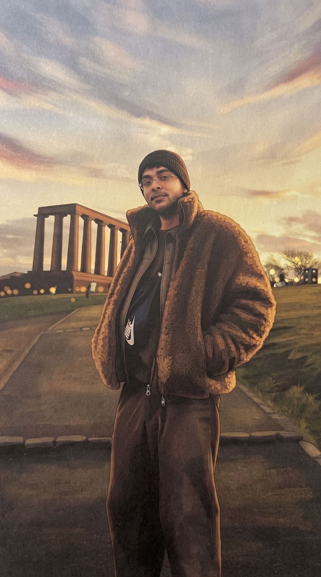 Illustrated portrait of Yash Nirwan on Calton Hill in Edinburgh at sunset, in a sherpa jacket and beanie, with the National Monument behind him